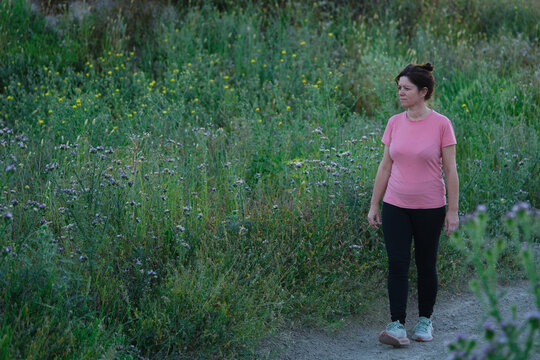 Woman walks along a path full of wildflowers