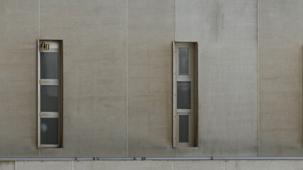 Fototapeta premium Modern minimalist facade with two vertical narrow windows on concrete wall