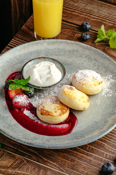 cottage cheese pancakes with sauce and jam on a plate