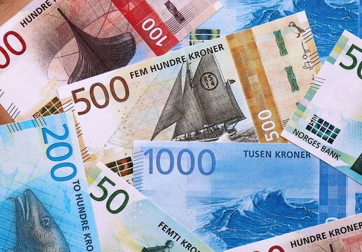 Norwegian krone money bills pile on table. Norway banknotes of NOK currency close up.
