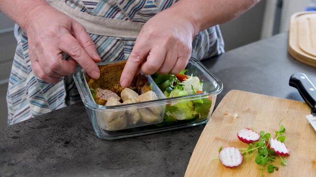Meal prep process packing healthy lunchbox with fresh food