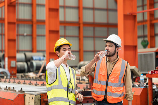 Technicians and supervisors are drinking water to cool off from the heat of working in the factory during the summer.