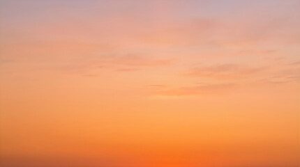 Fototapeta premium Warm orange sunset sky with soft clouds
