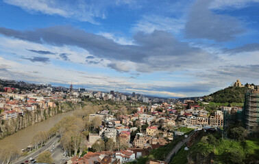 View of Tbilisi city across the Kura River during a sunny day © Nadzeya