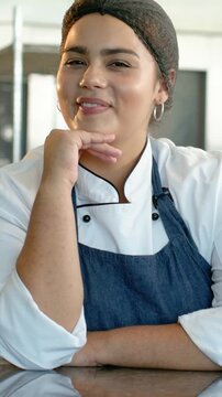 Vertical video: Reacting chef in chef coat glancing laughing reading prep counter at offscreen cue