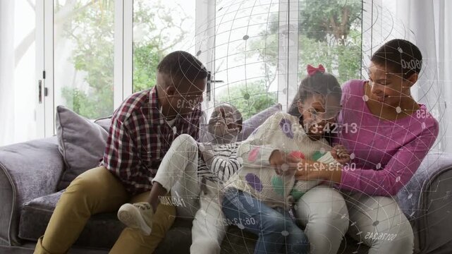 Dad leaning in tickling kids on sofa, parents bonding for ads, overlays floating over group