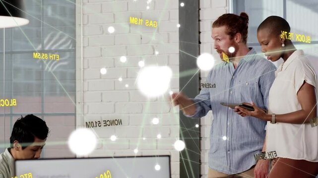 Business colleagues reviewing tablet data, woman tapping tablet causing animated overlay flaring