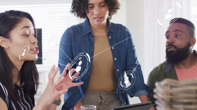 Seated woman pointing at tablet, starting animated network graphics linking team for business