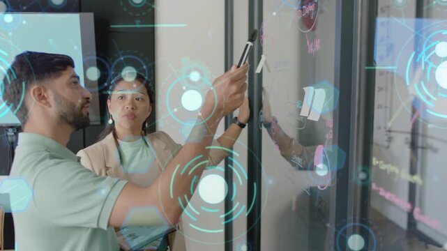 Woman checking tablet and pointing at glass, man writing notes as HUD guiding business plan