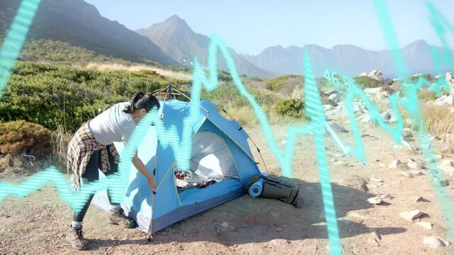 Woman camper adjusting blue tent entrance after arriving campsite, cyan waveform scrolling