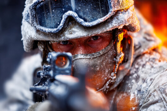 Focused soldier aiming through a weapon sight in extreme cold weather conditions with icy gear and intense backdrop flames during a military operation