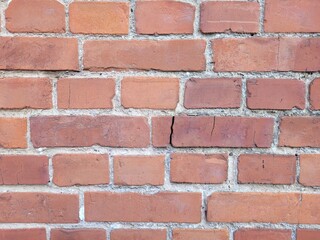 Fototapeta premium Macro Close-up of a Rustic Red Brick Wall, Detailed Texture of Weathered Masonry in Natural Daylight