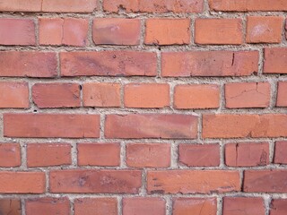 Obraz premium Macro Close-up of a Rustic Red Brick Wall, Detailed Texture of Weathered Masonry in Natural Daylight