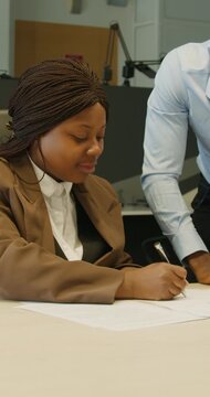 Black colleagues discussing and reviewing important documents