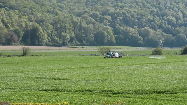 Un tracteur pulv&eacute;rise des produits phytosanitaires dans un champs