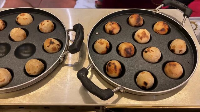 Golden-brown, ghee-laden Litti (roasted wheat balls) simmering on an electric cooktop, illustrating the fusion of traditional recipes with modern cooking technology.