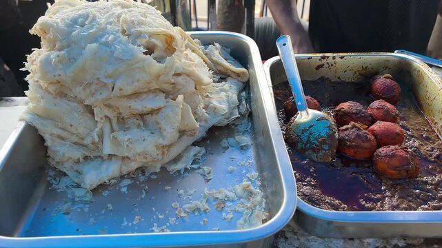 Pitai paratha served with egg curry in Bengali road side stall in Kolkata