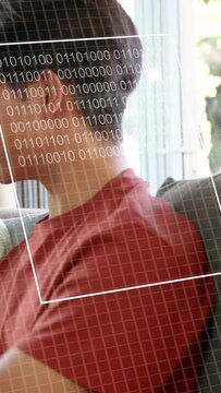 Vertical video: Teen on sofa grid appearing HUDs moving binary progress rings filling face for tech