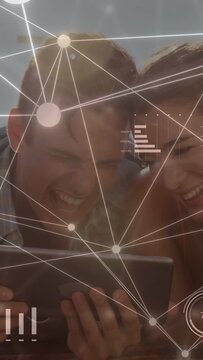 Vertical video: Couple angling tablet watching overlay animating nodes and bars, viewing tech data