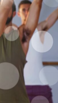 Vertical video: Two partners raising arms on cue in fitness studio, overlays guiding stretch