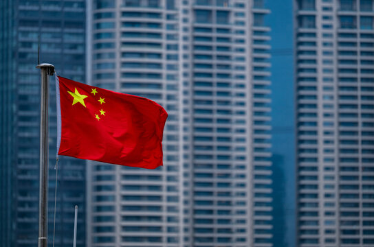 the Chinese flag with skyscrapers of Pudong in the back