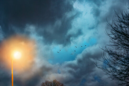 Evening Sky with Storm Clouds and Glowing Lamp