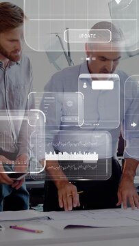 Vertical video: Design lead unrolling plans and pointing, team gathering, reviewing with HUD maps