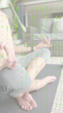 Vertical video: Woman settling on yoga mat forming mudra, causing green overlay fade for wellness
