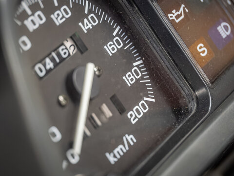 Close-up of an analog speedometer scale on a motorcycle.