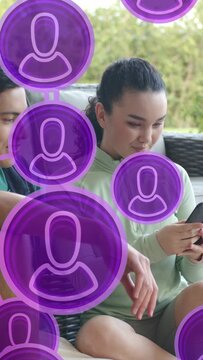 Vertical video: Couple sitting phone purple dots rising over them woman tapping man leaning AR tech