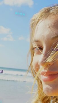 Vertical video: Woman turning to camera, frame tightening, sea wind moving hair overlays aiding ads