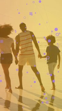 Vertical video: Cam panning dad walking kids, purple overlay over group, wet-sand reflecting travel