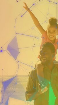 Vertical video: Dad lifting girl on shoulders at shore reaching sea as AR mesh drifting bonding