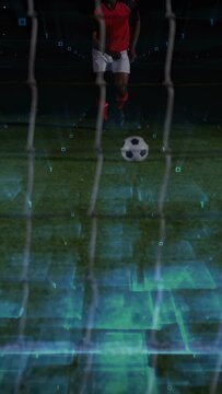 Vertical video: Soccer player closing in planting foot kicking ball past net with holo turf overlay