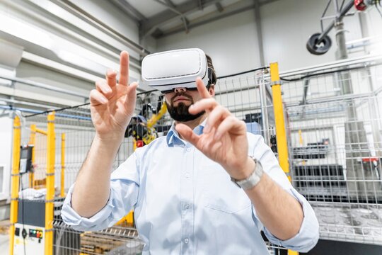 Engineer using Virtual Reality Simulator and gesturing at modern industry
