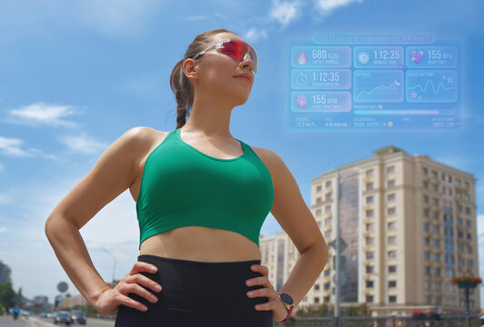 Athlete standing outdoors in city with augmented reality dashboard