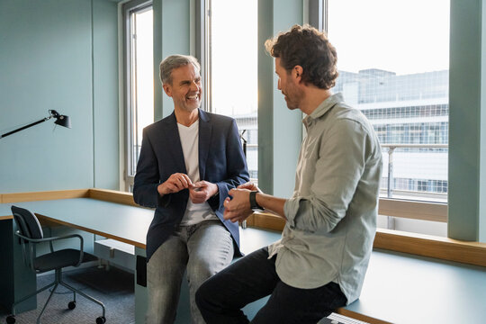Two people having a friendly discussion in a modern office setting