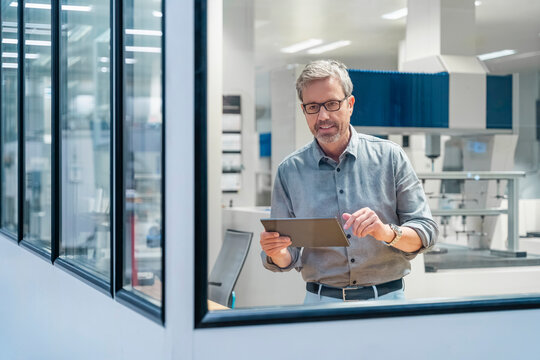 Engineer using tablet for measurement in modern production hall