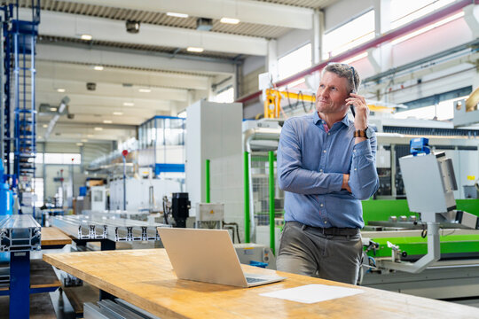 Manager talking on cell phone in production hall
