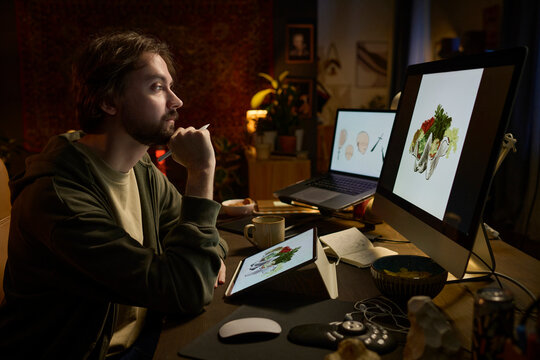 Freelance illustrator working on digital art in dark home office