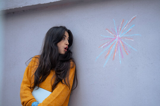 Surprised woman looking at colorful design on wall