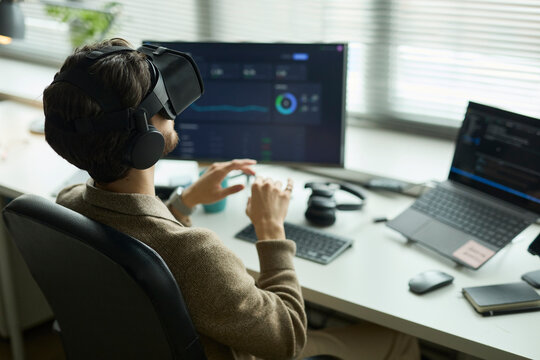 Programmer analyzing data with virtual reality headset in office