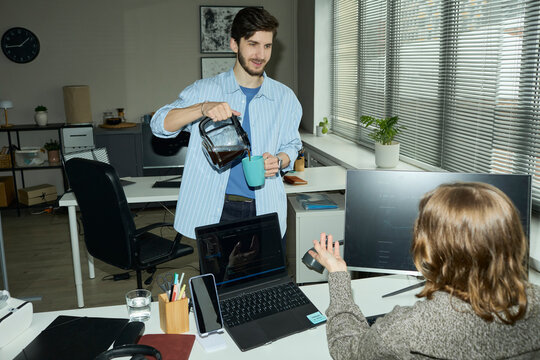 Programmer communicating with colleague during office coffee break
