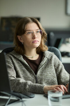 Programmer thinking while working on computer in corporate office