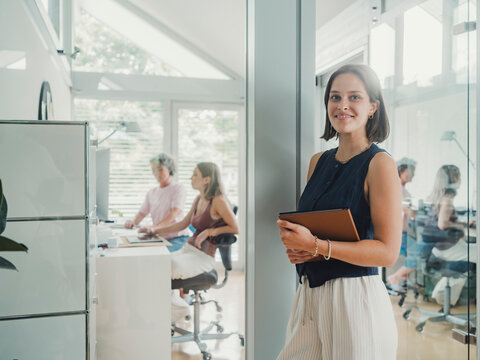 Woman holding tablet in modern home office creative agency