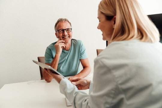Doctor giving advice to a smiling patient at a hospital