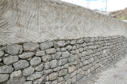 A two-toned wall blending natural stones with decorative cement.