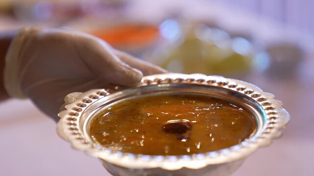 Close-up of traditional sauce being poured over hot soup, highlighting final serving touch, rich texture, and authentic Turkish cuisine presentation in a kitchen setting.