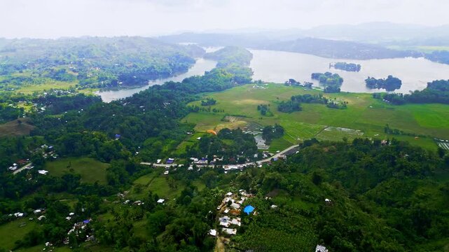 Aerial views of lush green rice paddies, a meandering river, and village settlements in Lake Sebu, South Cotabato, Philippines, illustrating a serene rural tropical landscape.