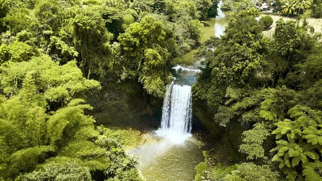 Cascading waterfalls flowing through dense tropical jungle and rainforest in Lake Sebu, South Cotabato, Philippines, showcasing vibrant greenery, river flow, and natural wilderness.